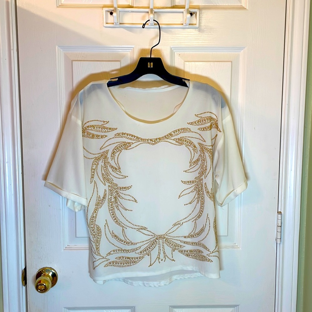 White shirt with gold stud design.